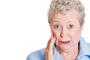 Closeup portrait, elderly business woman with tooth ache, crown problem, cavity pain, touching outside mouth with hand, isolated white background. Negative human emotion facial expression feeling